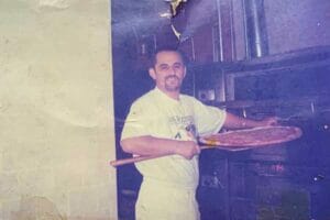 About a classic photo of Ray Koxha smiling while putting a pizza in the oven