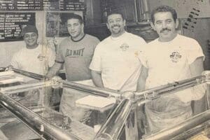 Vintage photo of Frank with staff at the pizza shop